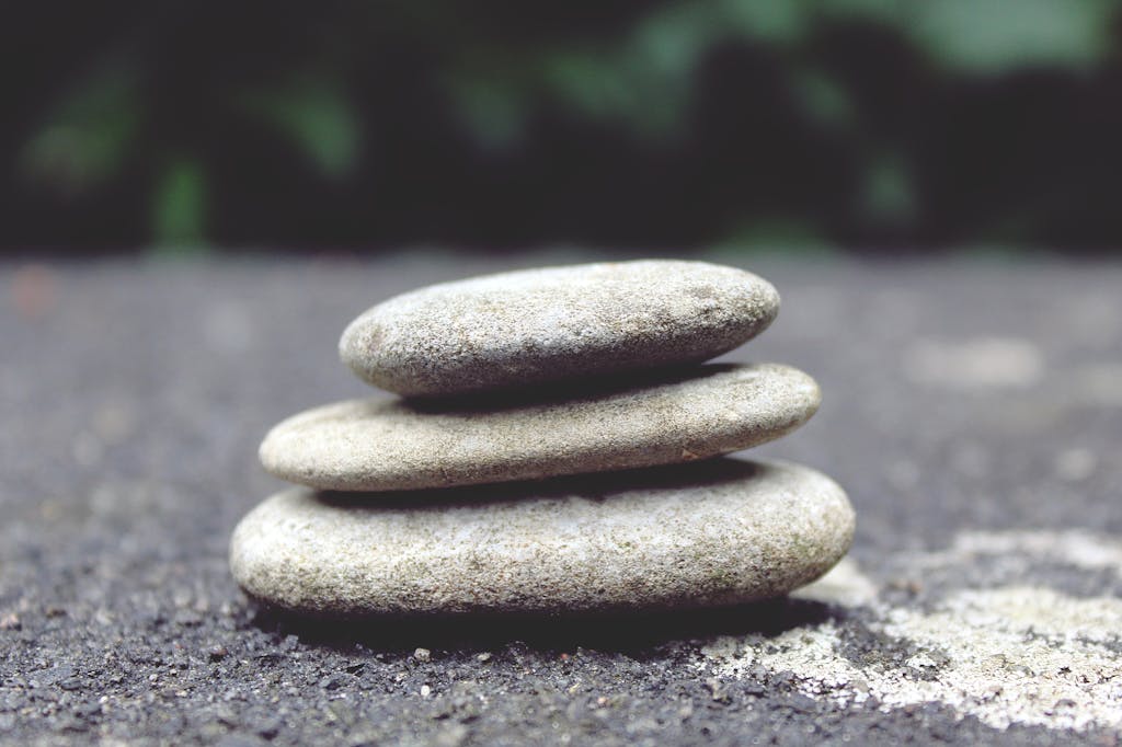 Close-up of balanced smooth stones on asphalt representing stability and calm.